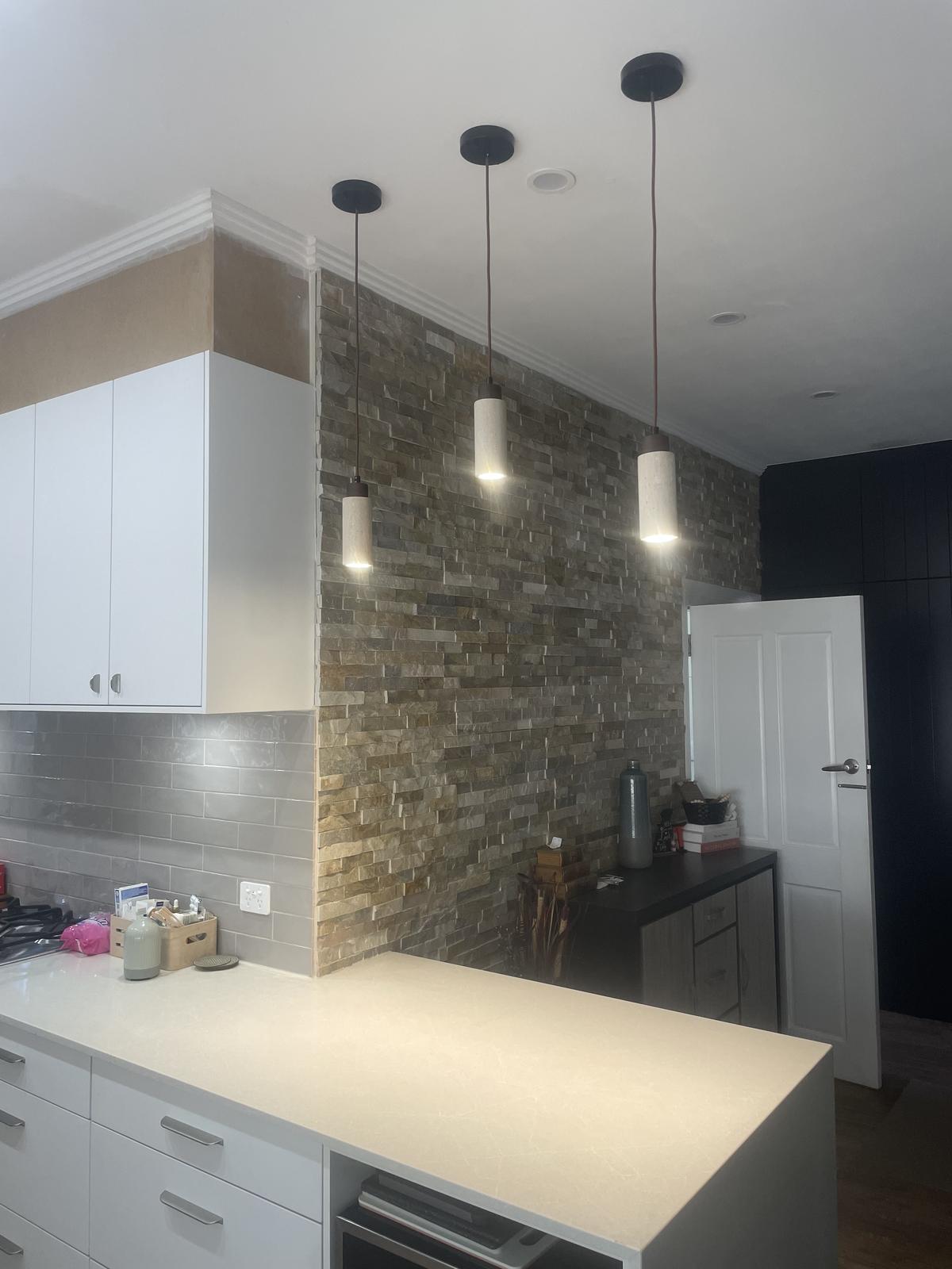Kitchen island pendant lighting with stone feature wall